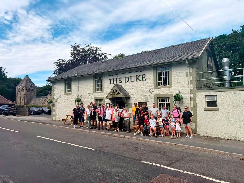 DadBodsFFC members and their families on a club walk, stopped outside a pub